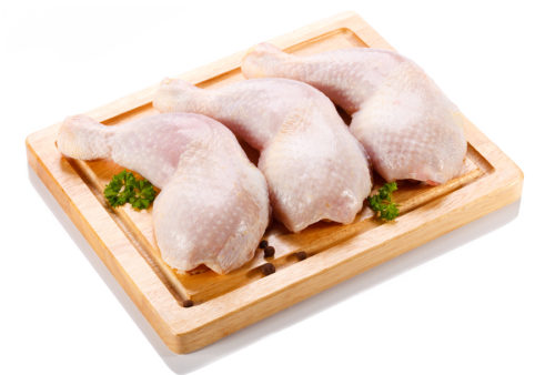 Raw chicken legs on cutting board